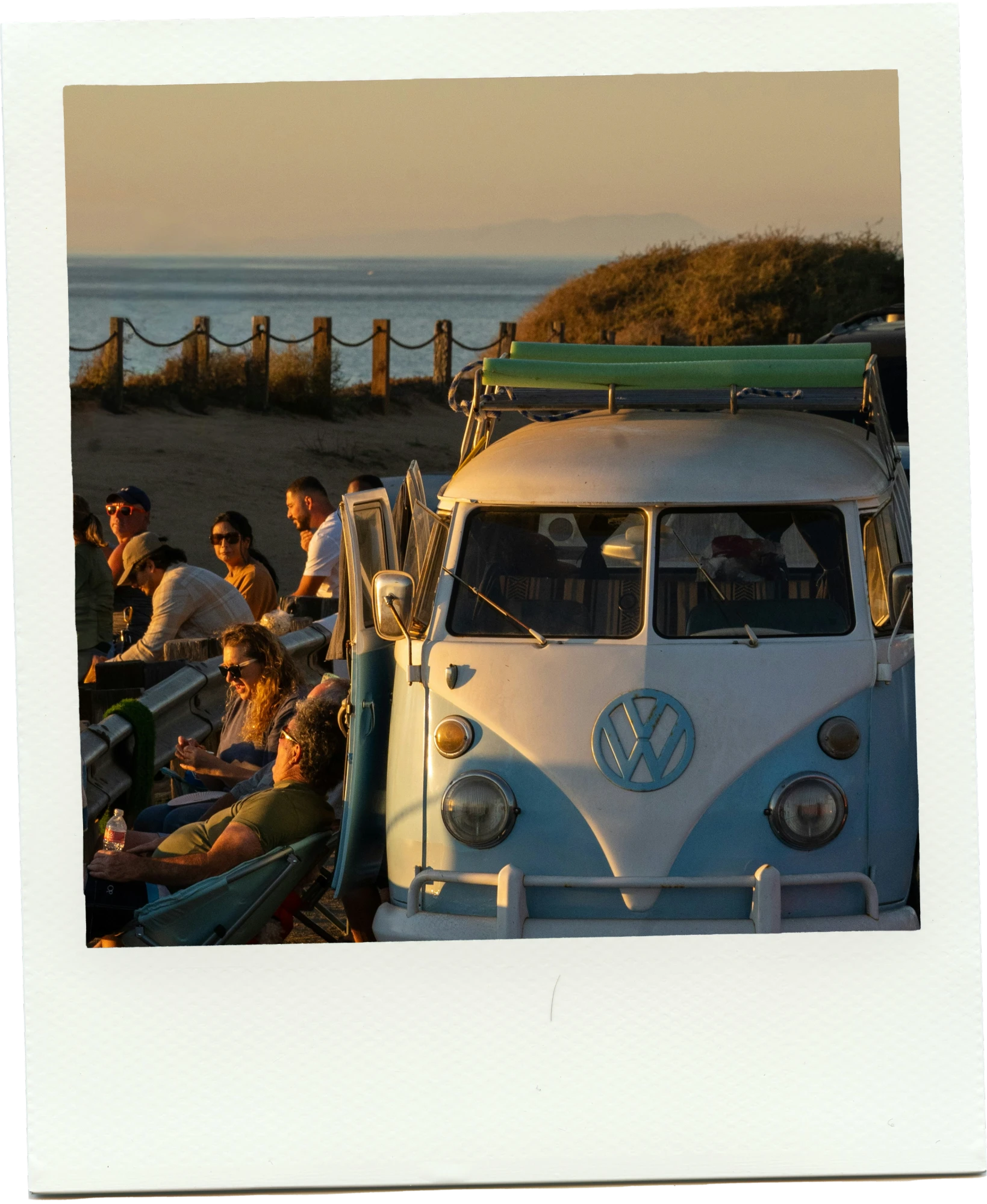 A vintage van and friends watching the sunset by the ocean
